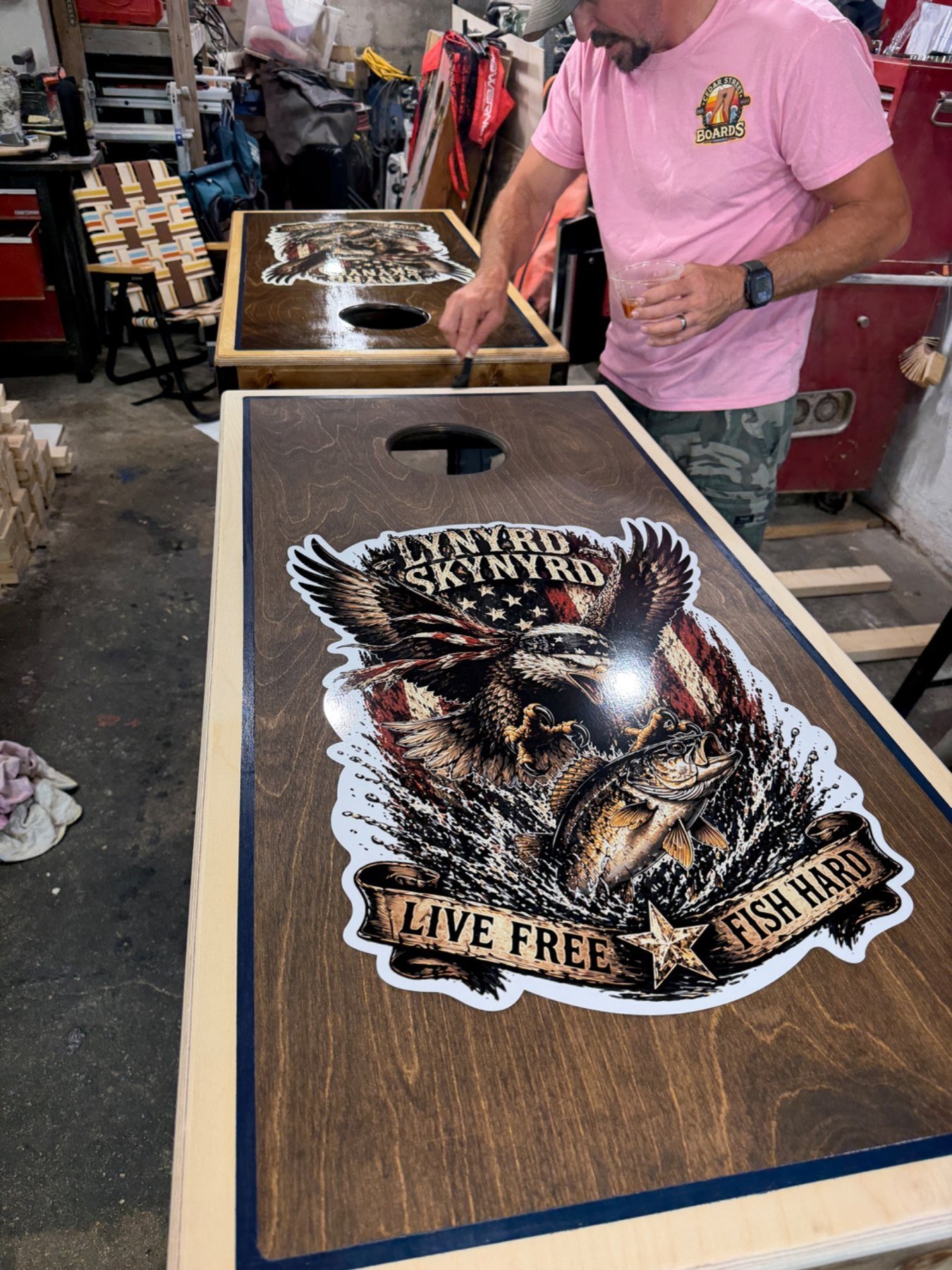 Finishing a custom cornhole board in the shop